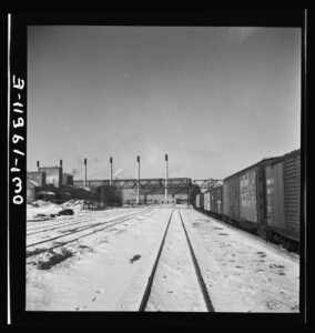Streator, Illinois. Going through the Atchison, Topeka and Santa Fe Railroad yard. In the background is a large bottling